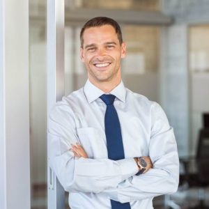 a man in a white shirt and blue tie smiling